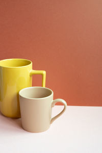 Close-up of coffee cup on yellow background