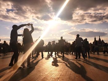 Group of people in city at sunset