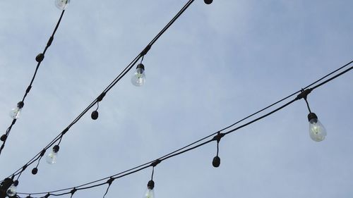 Low angle view of light bulbs against sky
