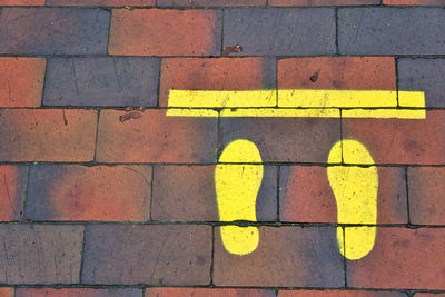 High angle view of yellow road marking on footpath