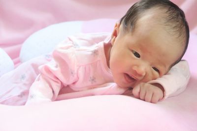 Portrait of cute baby lying on bed