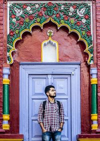 Man standing against door of historic building