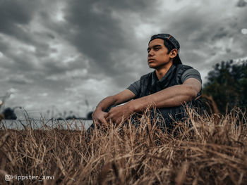 Young man looking away on field