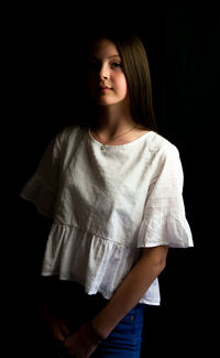 Portrait of a teenage girl over black background
