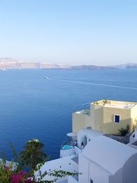 High angle view of buildings by sea against clear sky