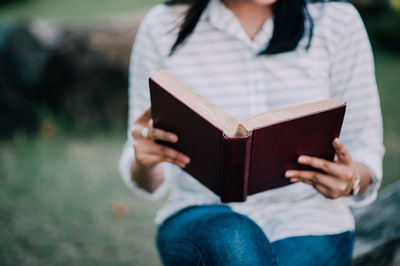 Midsection of woman holding book