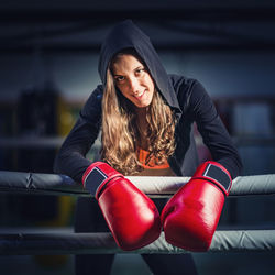 Portrait of smiling female boxer in ring