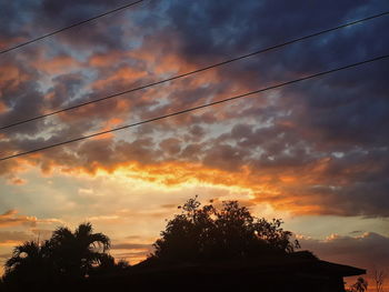 Low angle view of silhouette trees against sky at sunset