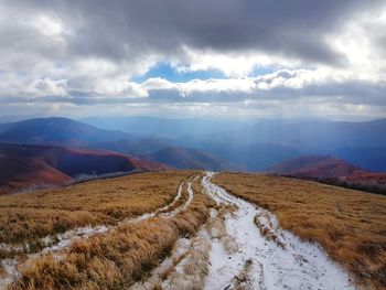 Scenic view of snow covered land against sky