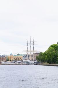 Sailboats in river against sky