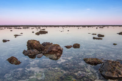 Scenic view of rocks in sea against sky