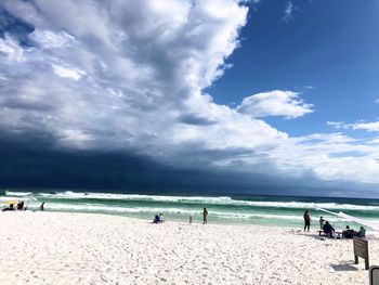 People on beach against sky
