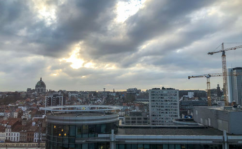 Buildings in city against cloudy sky