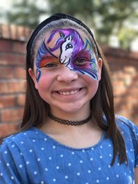 Close-up portrait of smiling girl with face paint