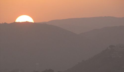 Scenic view of silhouette mountains against sky during sunset