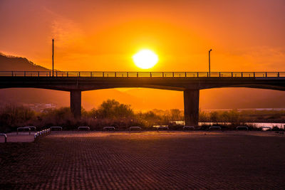 Bridge over river against sky during sunset