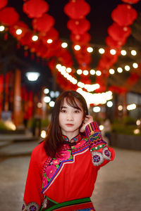 Portrait of beautiful young woman standing at night