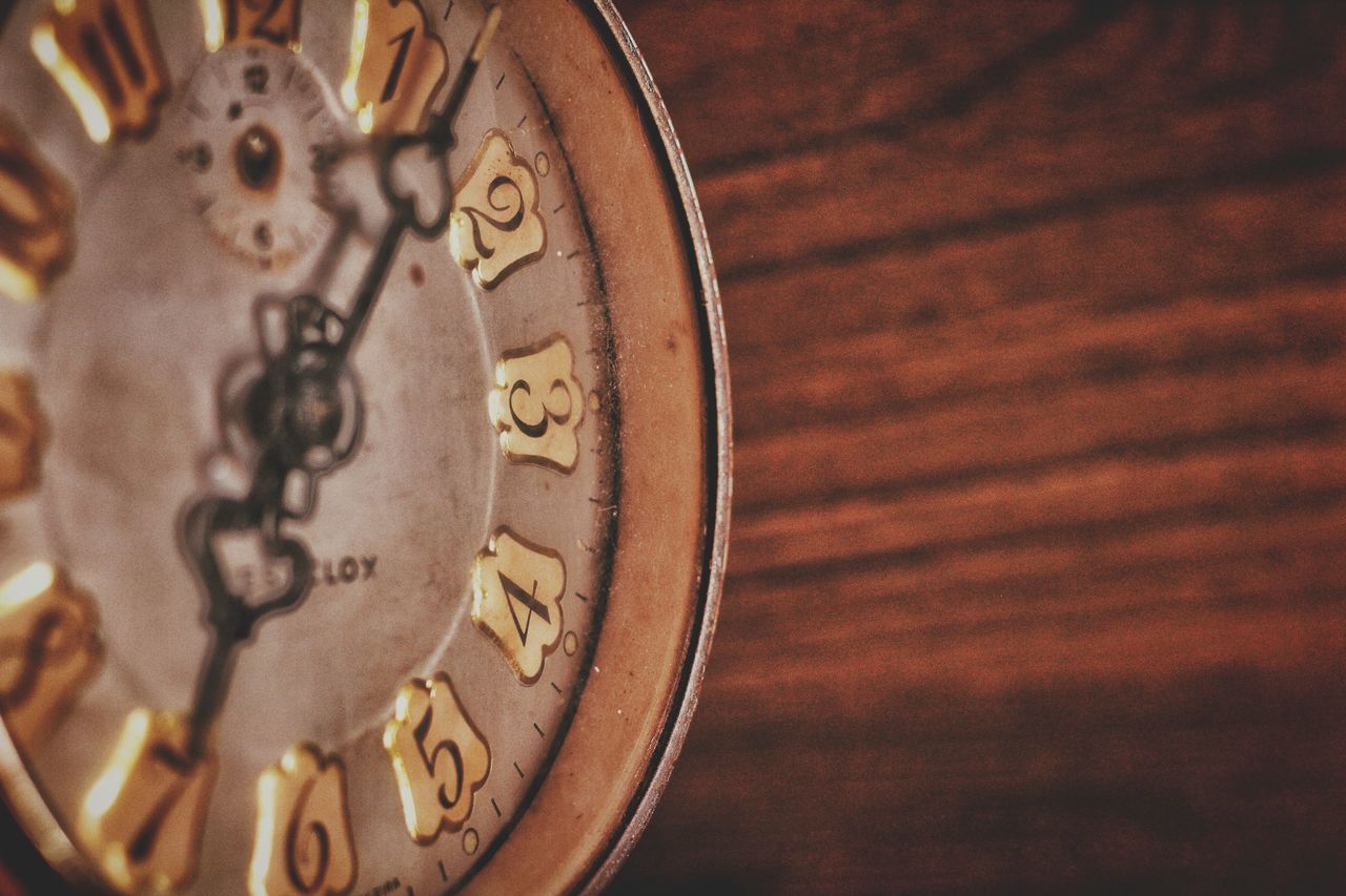 CLOSE-UP OF CLOCK ON METAL TABLE