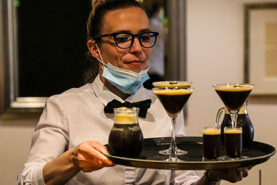 Midsection of man with drink on table in restaurant