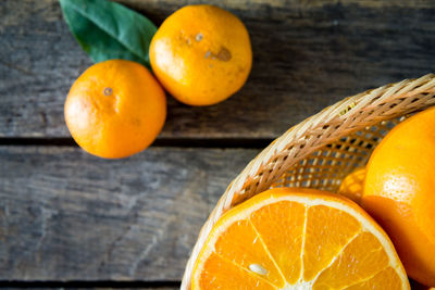 High angle view of orange fruits in basket on table