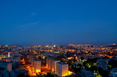 Illuminated cityscape against sky