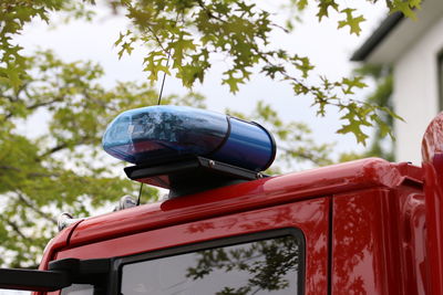 Close-up rear view of red car against trees