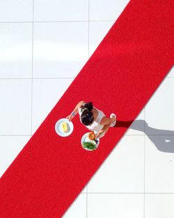 High angle view of woman on table by tiled floor