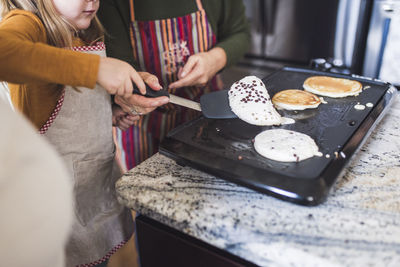 Close up of little girl flipping pancakes for breakfast