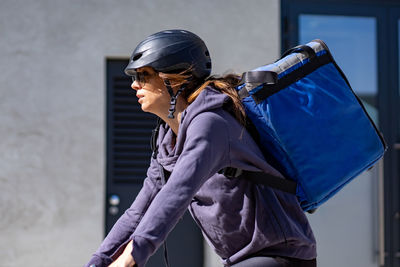 Delivery woman riding electric bicycle in city