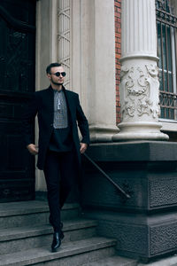 Portrait of young man standing against wall