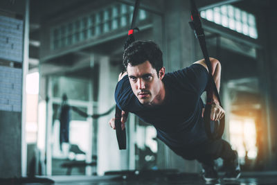 Man stretching resistance band in gym