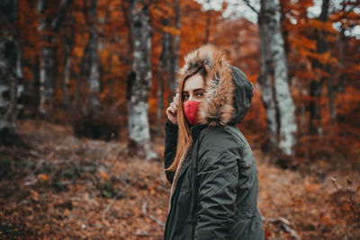 Portrait of man standing in forest during autumn