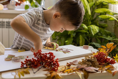 Boy playing with christmas tree at home