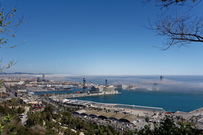 High angle view of city by sea against sky