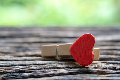 Close-up of heart shape and clothespin on wooden table