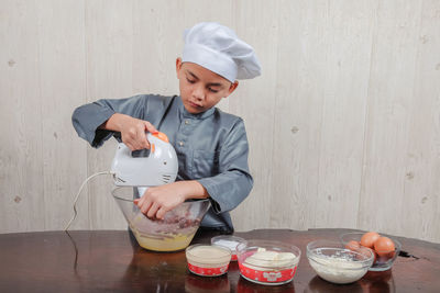 Boy mixing food in bowl at home