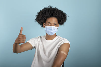 Portrait of man standing against blue background