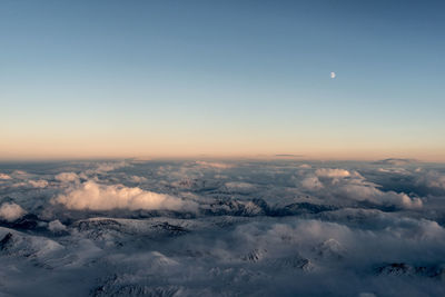 Aerial view of clouds over mountain against sky during sunset