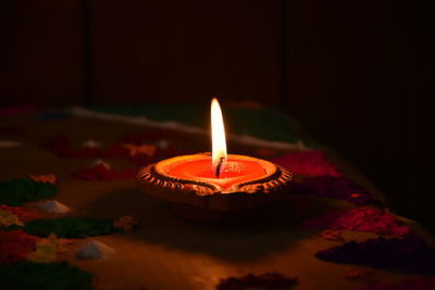 Close-up of diya on floor in darkroom