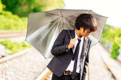 Woman with umbrella standing on rainy day