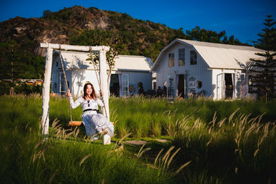 Full length of woman on field against building