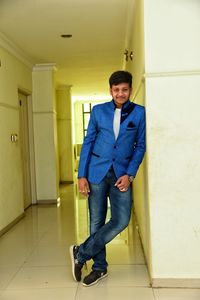 Portrait of young man standing against wall