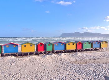 Multi colored beach huts against blue sky