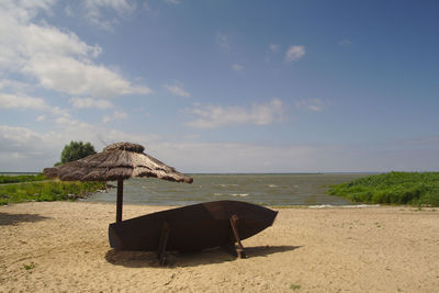 Lifeguard hut on beach against sky