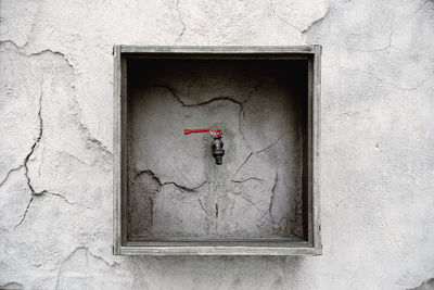Faucet on concrete cracked wall