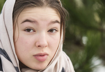 Teen girl in headscarf close-up face - winter outdoors