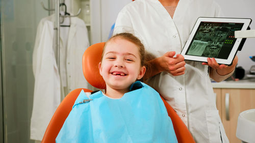 Smiling girl sitting at dental clinic
