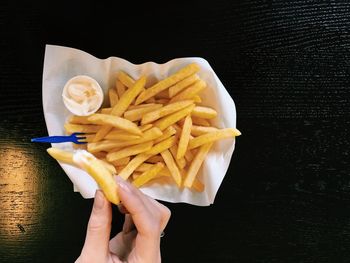 Cropped hand of woman with french fries
