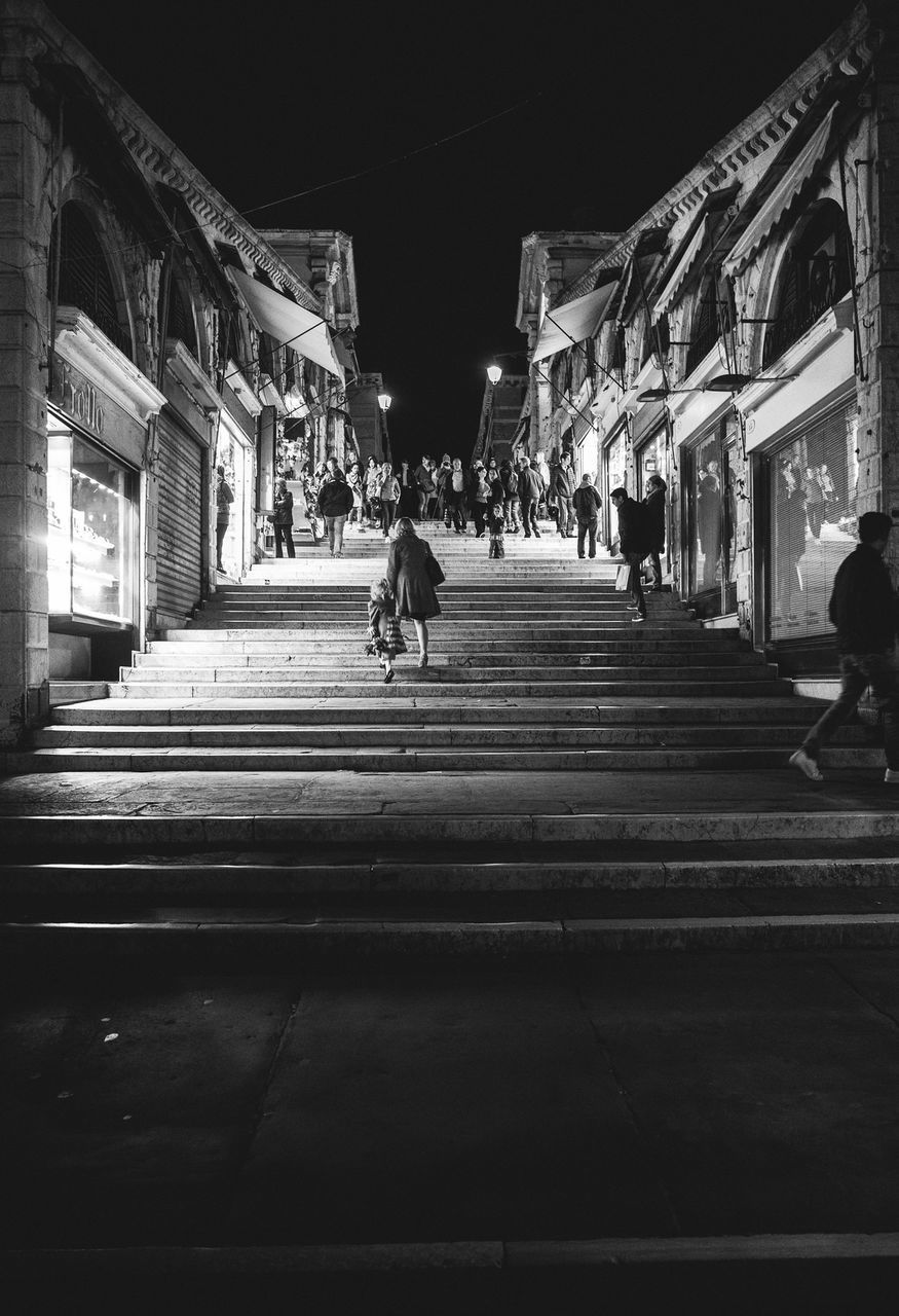 architecture, building exterior, built structure, steps, men, the way forward, walking, person, incidental people, city, travel destinations, illuminated, night, travel, lifestyles, street, steps and staircases, history, city life