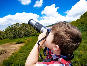 Boy on landscape against sky